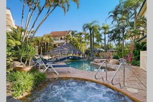 努萨角Haven on Noosa Hill - sunset views, pools, spa的庭院内带热水浴池的游泳池