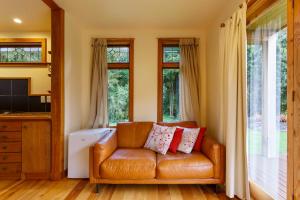 弗朗兹约瑟夫卡希尔度假屋的客厅设有皮沙发,配有窗户