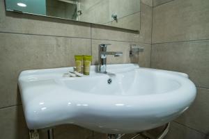比雷埃夫斯阿尔戈酒店的浴室设有白色水槽和镜子