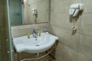 比雷埃夫斯阿尔戈酒店的一间带水槽的浴室和墙上的一部电话