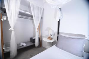 斯基亚索斯镇恩特诺斯生活旅馆的卧室配有白色床和白色窗帘