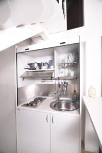 斯基亚索斯镇恩特诺斯生活旅馆的厨房配有白色橱柜和水槽