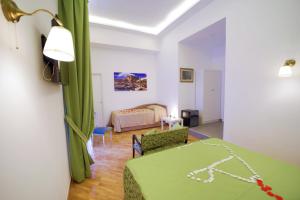 那不勒斯迪帕尔马套房旅馆的一间设有床铺和客厅的房间