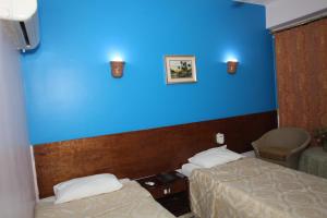 卢克索Rezeiky Hotel & Camp的一间设有两张床和蓝色墙壁的客房