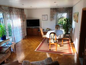 齐恩多夫Ferienwohnung am Wald - Nähe Funpark的客厅配有桌椅和电视。
