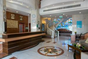 阿吉曼Ramada by Wyndham Beach Hotel Ajman的大楼内带楼梯的大堂