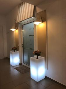 维也纳苏菲公寓式酒店的一间有两只白色花瓶的房间,里面装有鲜花