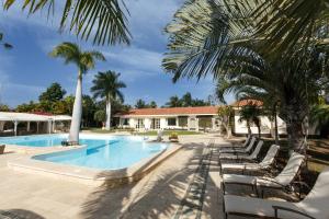 马斯帕洛马斯Villa Piera Maspalomas的一个带躺椅的游泳池,棕榈树
