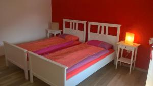 加维科利亚诺Ca da la nona的卧室设有两张床铺和红色的墙壁