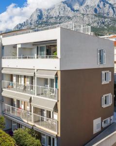 马卡尔斯卡Apartments House Filipović的公寓大楼的背景是一座山