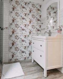 包道乔尼托毛伊Éliás Borbirtok的浴室设有白色水槽和花卉壁纸