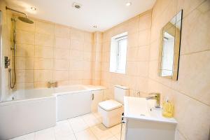 桑德兰Sunderland Short Stays 2 bedroom apartment Free Parking Fulwell SR6的带浴缸、卫生间和盥洗盆的浴室