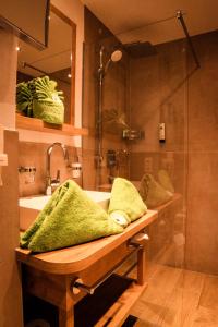 坦海姆Hotel Bogner Hof的浴室配有水槽和带绿色毛巾的淋浴