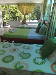 莱蒂西亚Hospedaje casa Lucía的卧室内的两张床,配有绿色和蓝色的床单