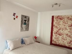 里斯本Studio Telheiras 2的卧室配有一张床,墙上挂有绘画作品