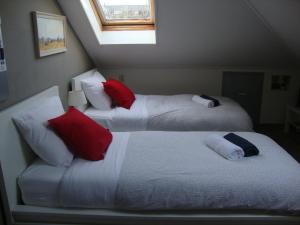 PoortugaalValckesteyn的两张带红色和白色枕头的床