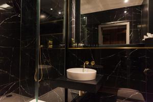 比斯特The Chesterton Hotel的黑色浴室设有水槽和淋浴