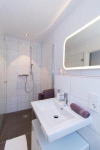 诺伊恩斯塔特阿姆科黑尔Appartement Neuenstadt in ruhiger Lage im Wohngebiet的白色的浴室设有水槽和镜子