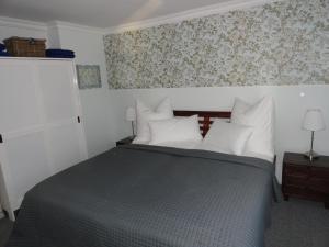 卡普特Cottage Ferienwohnung mit Seeblick的一间卧室配有一张带白色枕头和壁纸的床。