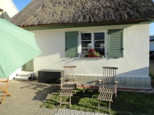 卡普特Cottage Ferienwohnung mit Seeblick的房子前面的两把椅子和一张桌子