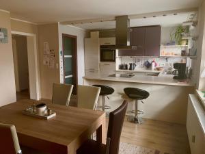 GoldkronachFerienwohnung Monika的厨房以及带木桌和椅子的用餐室。