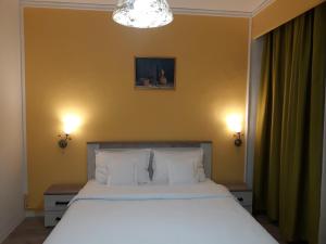 蒂米什瓦拉Pensiunea Sydney的一间卧室配有一张带两盏灯的大型白色床。
