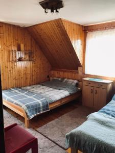 KrasnogrudaDOM NaD JEZIOREM的卧室配有木墙内的一张床