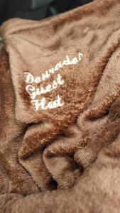 多拉杜斯DOURADOS GUEST FLAT HOUSE的棕色的毯子,上面写着有控制的研究
