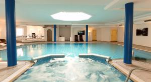 奥伯斯特多夫Elements Hotel Christlessee的一座建筑中带蓝色柱子的大型游泳池