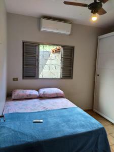 多拉杜斯DOURADOS GUEST FLAT HOUSE的一间卧室配有一张带蓝色毯子的床和窗户。