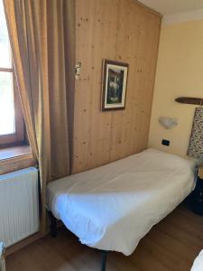 卡瓦莱塞Chalet montagna e relax Volpe Rossa的木墙客房的一张床位