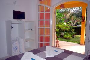 乌巴图巴Pousada Capim Melado的客房设有一张床,并可通往庭院。