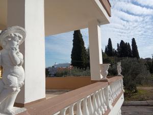 莫诺波利Le dimore di Flora的阳台上的白色雕像,背后是树木