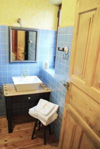 Pajares de los OterosHostal Los Oteros的蓝色瓷砖浴室设有水槽和镜子