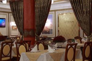 波尔塔瓦Hotel Aristokrat的用餐室配有桌椅和窗帘