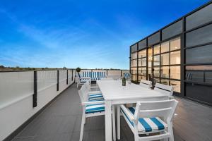 墨尔本The Hamptons Apartments - St Kilda的屋顶阳台配有桌椅