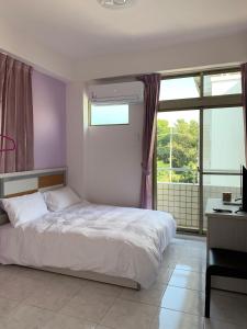 Minxiong金桔民宿的一间卧室设有一张床和一个大窗户