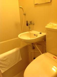 唐津庄内酒店的浴室配有盥洗盆、卫生间和浴缸。