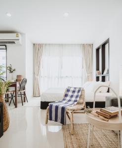 曼谷Siamplaengna Residence สยามแปลงนา เรสซิเดนท์的白色卧室配有床、椅子和桌子