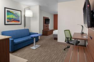 科达伦科达伦I-90公路11号出口快捷假日&套房酒店的酒店客房配有蓝色的沙发和书桌