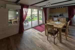 Suure-Rakke凯威瑞纳度假屋的厨房以及带木桌和椅子的用餐室。