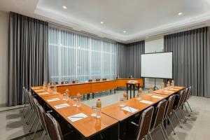 雅加达Amaris Hotel Slipi的大型会议室,配有长桌子和椅子