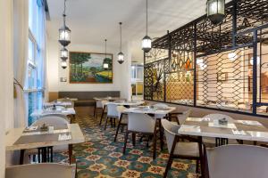 日惹KHAS Tugu Hotel Yogyakarta的一间在房间内配有桌椅的餐厅