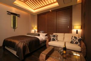 KoshigayaHOTEL W-PREMIUM -W GROUP HOTELS and RESORTS-的一间卧室配有一张床、一张沙发和一张桌子