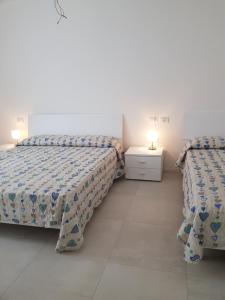 利多迪耶索罗Cala Blu Residence con piscina-Centralissimo Lido di Jesolo的白色客房的两张床,配有两盏灯