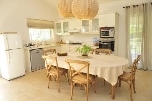 Rodrigues IslandLétan Lontan的厨房配有桌椅和白色冰箱。