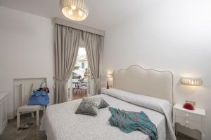 阿马尔菲Palazzo Gargano Amalfi的白色的卧室配有带枕头的床