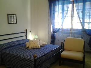 蒂贾诺La Baronessa的卧室配有床、椅子和窗户。