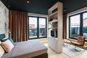 汉堡ipartment Hamburg HafenCity的一间卧室配有一张床和一台电视,部分设有窗户。