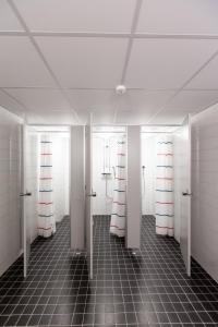 万塔万塔机场奥卢弗雷蒙旅舍的浴室设有粉色和白色的门,铺有瓷砖地板。